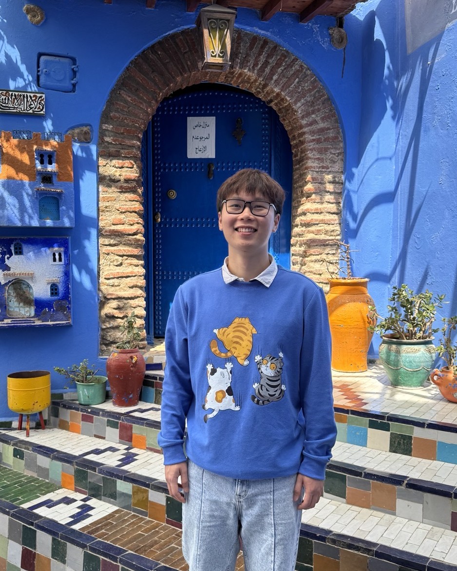 Tuan Anh Pham in front of a blue doorway in Chefchaouen